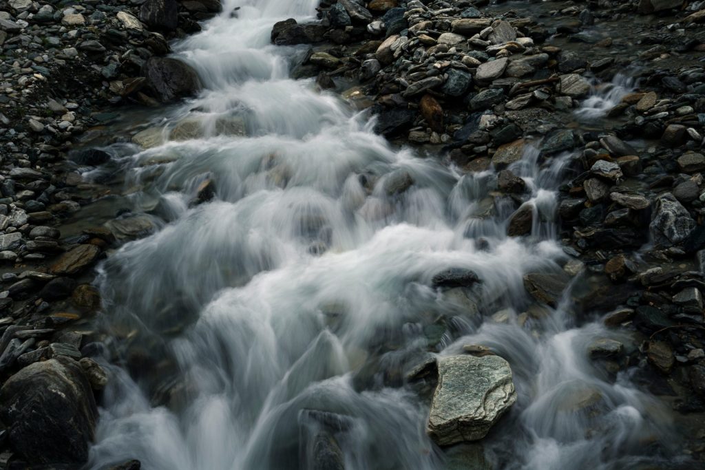 water falls on rocky shore during daytime
